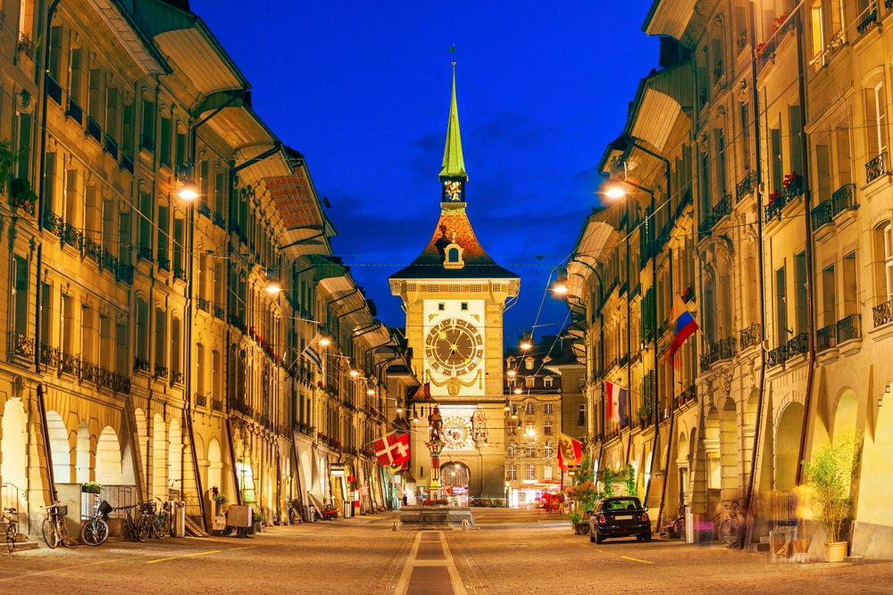 Die Kramgasse in der Abenddämmerung: die beleuchteten Lauben zu beiden Seiten, in der Mitte der Zytglogge-Turm.